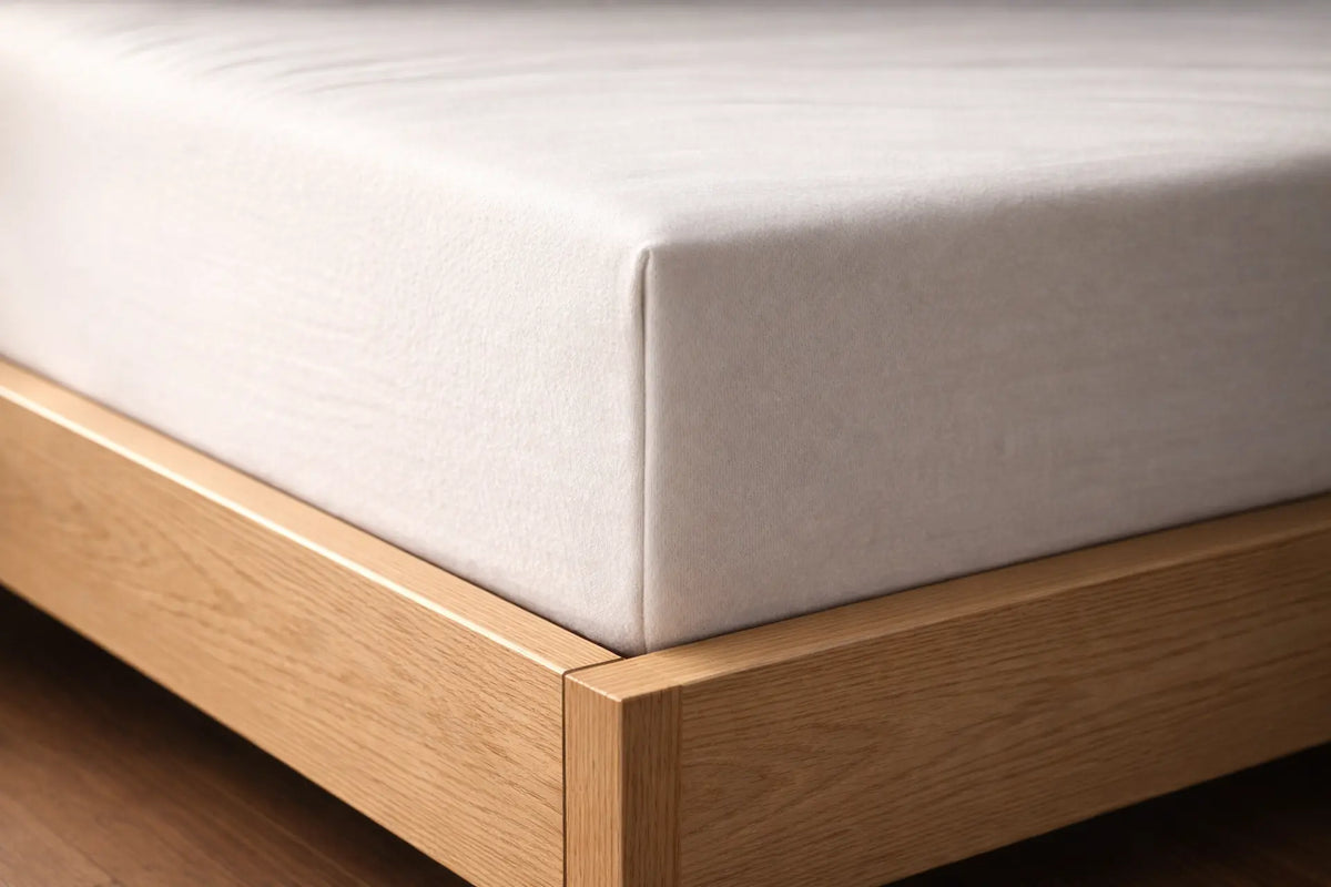 Hoek van bed met matras en hoeslaken eromheen