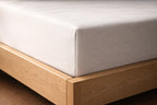 Hoek van bed met matras en hoeslaken eromheen