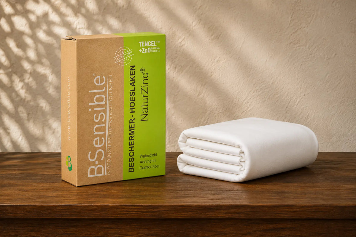 Sfeerbeeld van verpakking en opgevouwen matrasbeschermer op een houten tafel