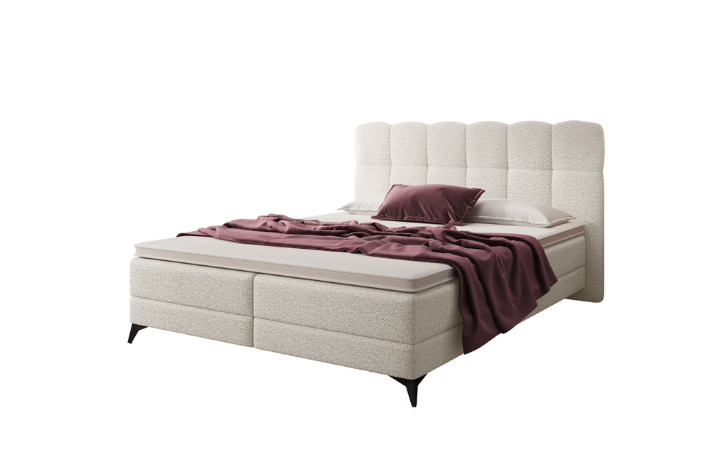 Cremekleurige boxspring met aubergine plaid en kussen
