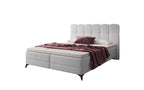 Madison boxspring in lichtgrijze  bouclé bekleding, met aubergine plaid en kussen.